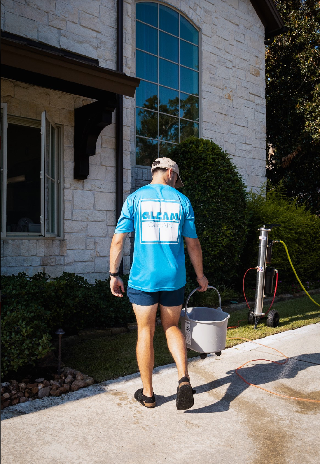Gleam Clean technician carrying a bucket, ready to clean windows